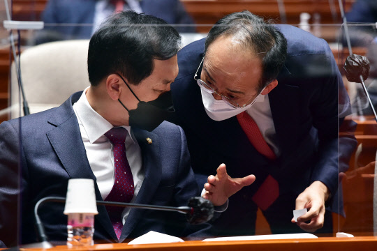 김기현 국민의힘 대표 권한대행 겸 원내대표(왼쪽)와 추경호 원내수석부대표가 12일 국회에서 열린 의원총회에서 논의하고 있다.  연합뉴스